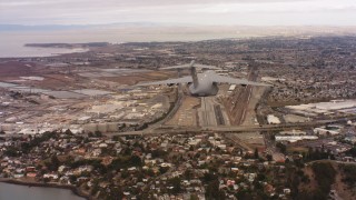 4K stock footage aerial video of following a Boeing C-17 flying over industrial buildings in Northern California Aerial Stock Footage | WAAF05_C069_0118C8