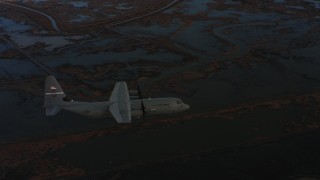 4K stock footage aerial video of a Lockheed Martin C-130J flying over wetlands at twilight in Northern California Aerial Stock Footage | WAAF06_C006_0119G1