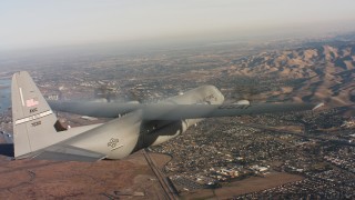 4K stock footage aerial video of a Lockheed Martin C-130J over residential neighborhoods at sunset in Northern California Aerial Stock Footage | WAAF06_C008_0119Q1