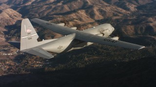 4K stock footage aerial video of a Lockheed Martin C-130J flying over hills at sunset in Northern California Aerial Stock Footage | WAAF06_C011_011979