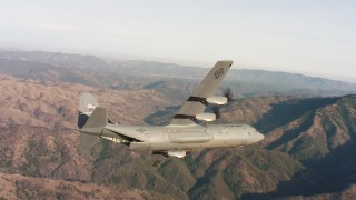 4K stock footage aerial video of a Lockheed Martin C-130J in flight over hills at sunset in Northern California Aerial Stock Footage | WAAF06_C018_0119HJ