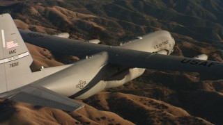 4K stock footage aerial video of a Lockheed Martin C-130J flying over rolling hills at sunset in Northern California Aerial Stock Footage | WAAF06_C029_0119C1