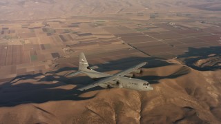 4K stock footage aerial video of a Lockheed Martin C-130J flying over hills and farms at sunset in Northern California Aerial Stock Footage | WAAF06_C036_0119QH