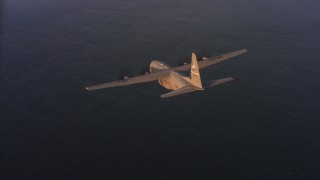 4K stock footage aerial video fly around a Lockheed Martin C-130J over the ocean at sunset in Northern California Aerial Stock Footage | WAAF06_C061_0119SS