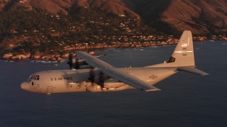 4K stock footage aerial video of a Lockheed Martin C-130J in flight over the ocean near the coast at sunset, Northern California Aerial Stock Footage | WAAF06_C062_0119BD