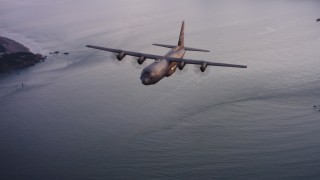 WAAF06_C085_0119X1 - 4K stock footage aerial video of a Lockheed Martin C-130J flying over the ocean toward San Francisco Bay at sunset, California 