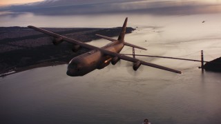 WAAF06_C087_0119KX - 4K stock footage aerial video of a Lockheed Martin C-130J flying over the Golden Gate Bridge at sunset, California