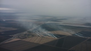 4K stock footage aerial video of smoke rising from farm fields in Northern California Aerial Stock Footage | WAAF07_C081_0119BK