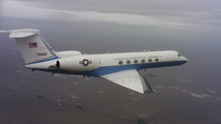 WAAF08_C037_0119GC - 4K stock footage aerial video of a Gulfstream C-37A flying over farmland in Northern California