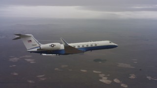 WAAF08_C038_0119H8 - 4K stock footage aerial video reveal a Gulfstream C-37A in flight over farms in Northern California