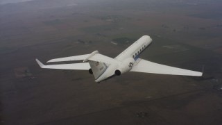 WAAF08_C039_0119FF - 4K stock footage aerial video of a Gulfstream C-37A flying high above farm fields in Northern California