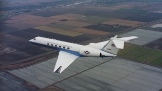 4K stock footage aerial video of a Gulfstream C-37A flying over covered farm fields in Northern California Aerial Stock Footage | WAAF08_C056_0120GH_S000